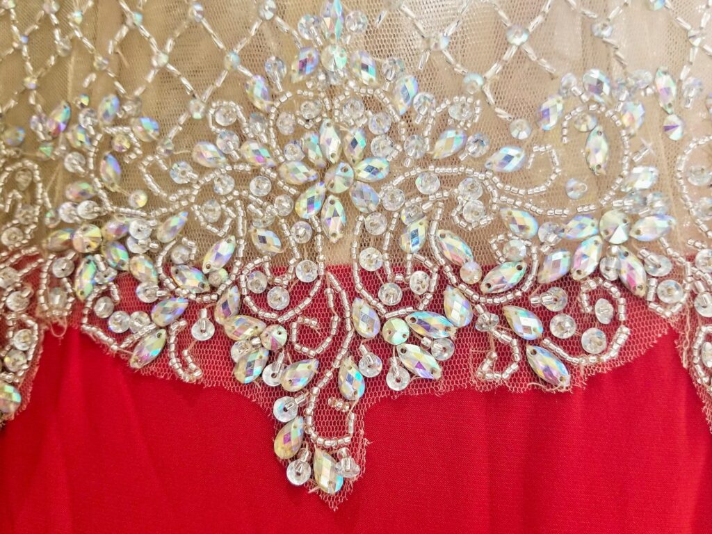 The rich delicate patterns of embroidered lace and rhinestones are incorporated in a close-up of the